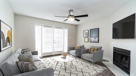 a living room with couches and a ceiling fan and a fireplace